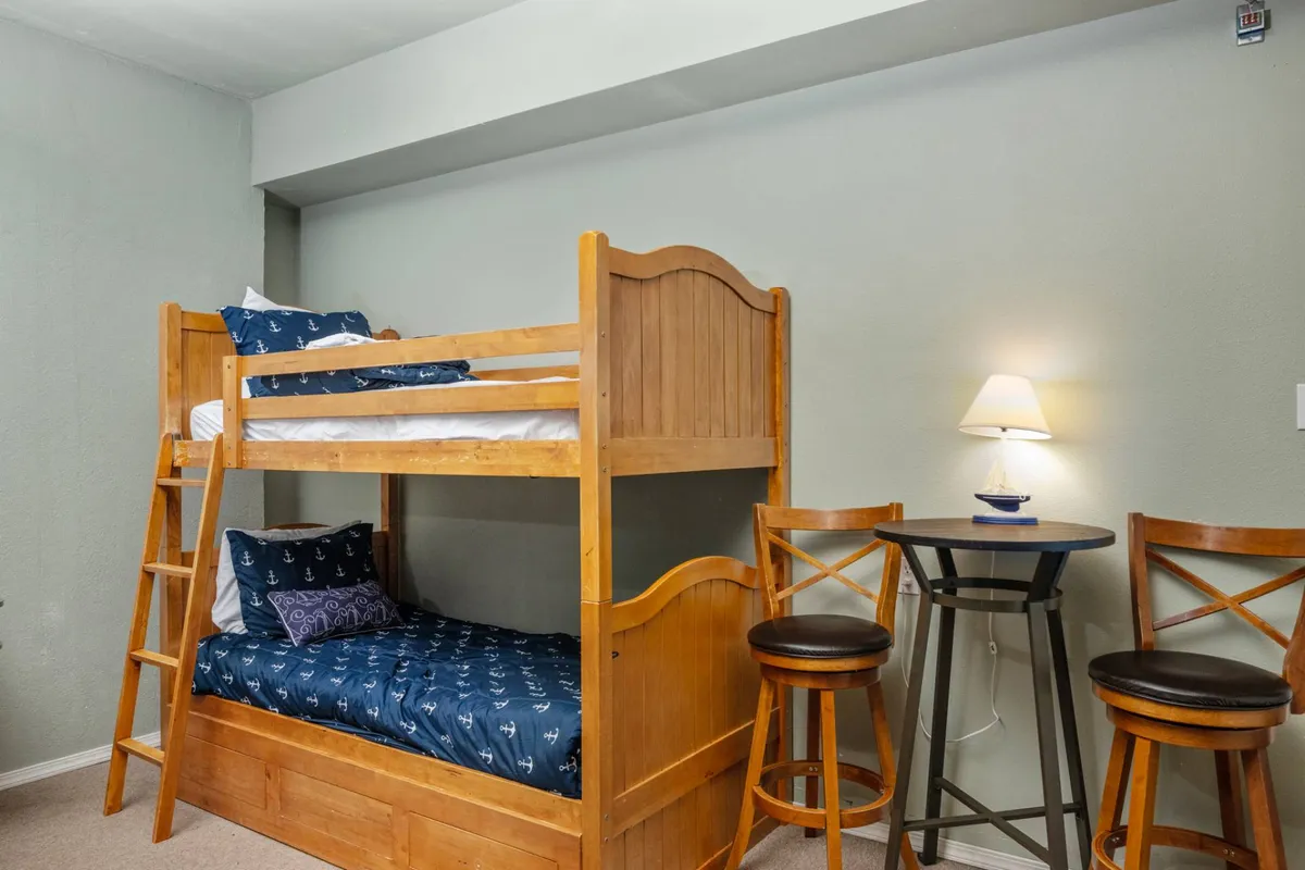 A snug nook with a bunk bed, a small table and chairs, and a warm lamp. The playful arrangement encourages board games, late-night chats, and the creation of lasting sleepover memories.
